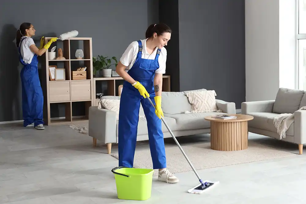 Junge Reinigungskräfte putzen im Zimmer